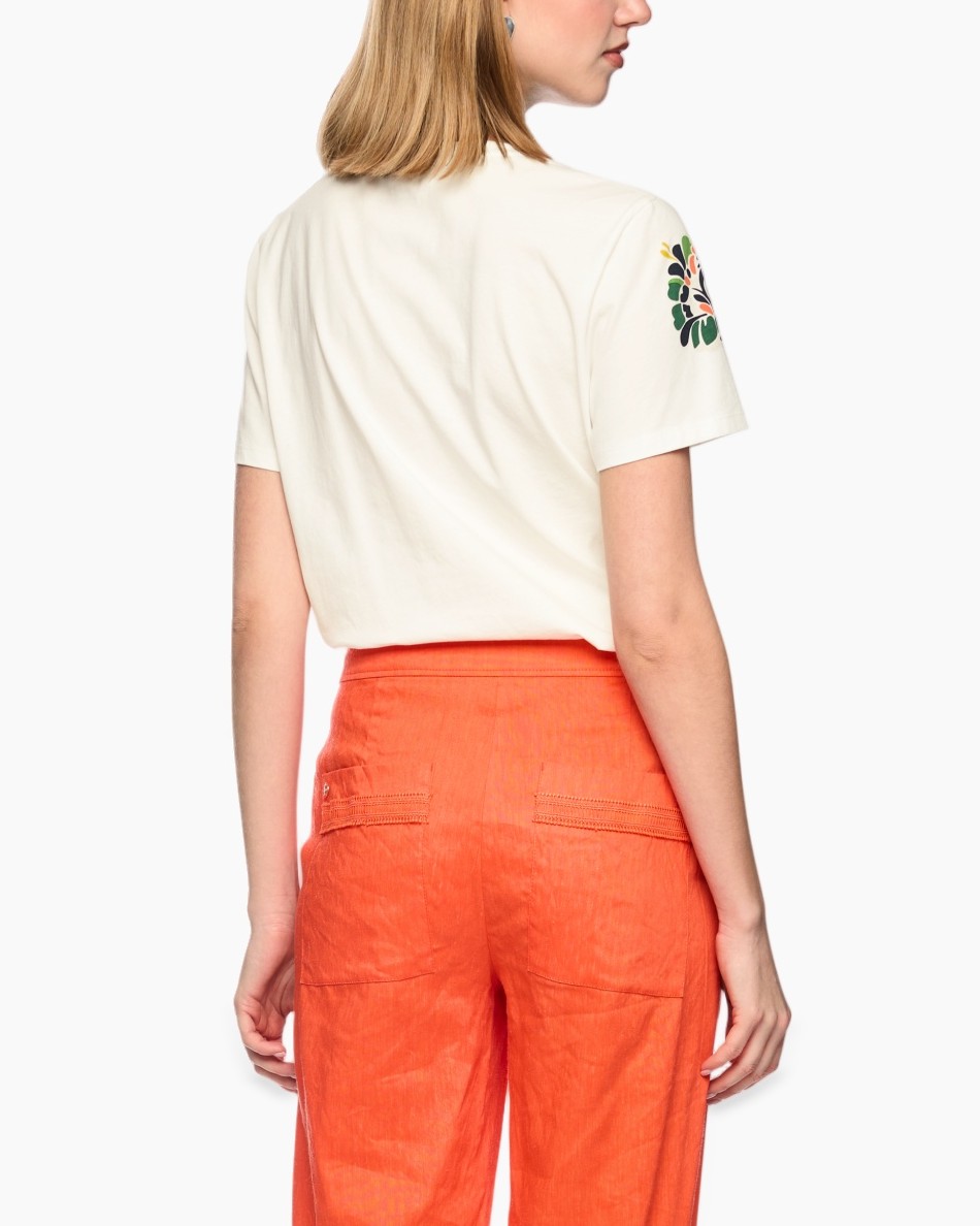 short-sleeve tee, embroidered floral, cream white, linen blend? (fabric not visible), orange pants, contrast embroidery, round neck, casual outfit