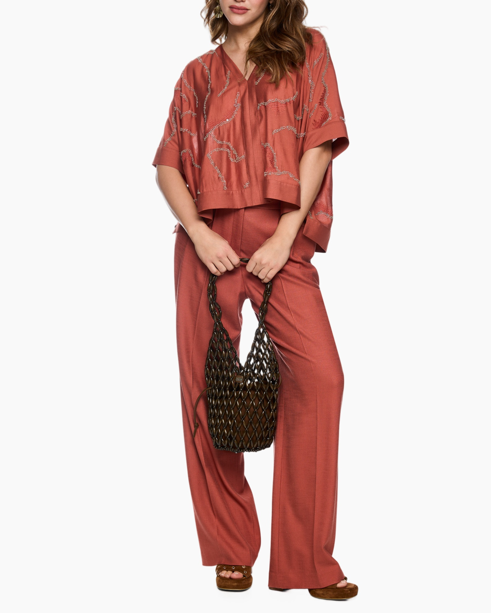 women's outfit, ruched top, wide-leg pants, rust red, woven bag