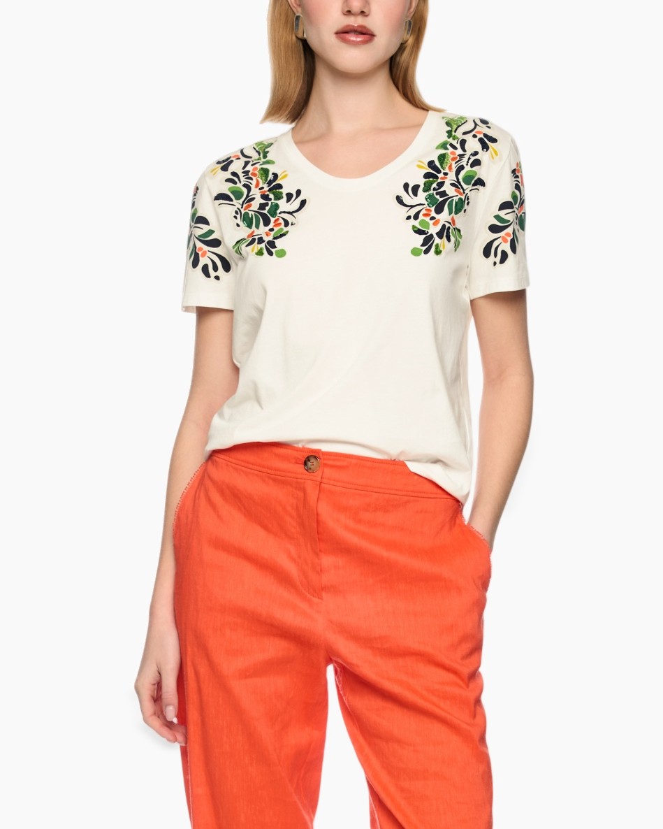 short-sleeve tee, embroidered floral, cream white, linen blend? (fabric not visible), orange pants, contrast embroidery, round neck, casual outfit