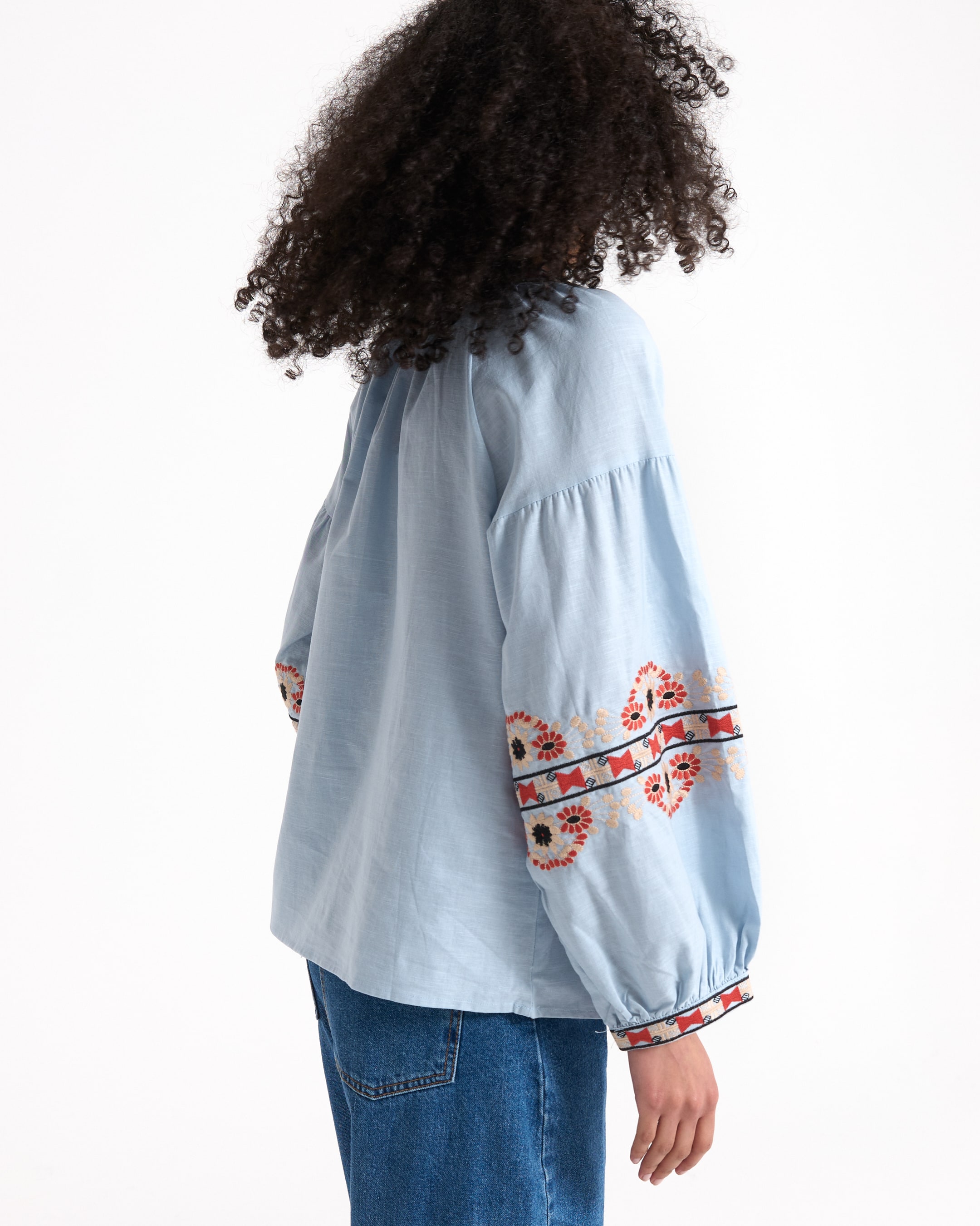 light_blue_top, embroidered_sleeves, puff_sleeves, loose_fit, blue_jeans