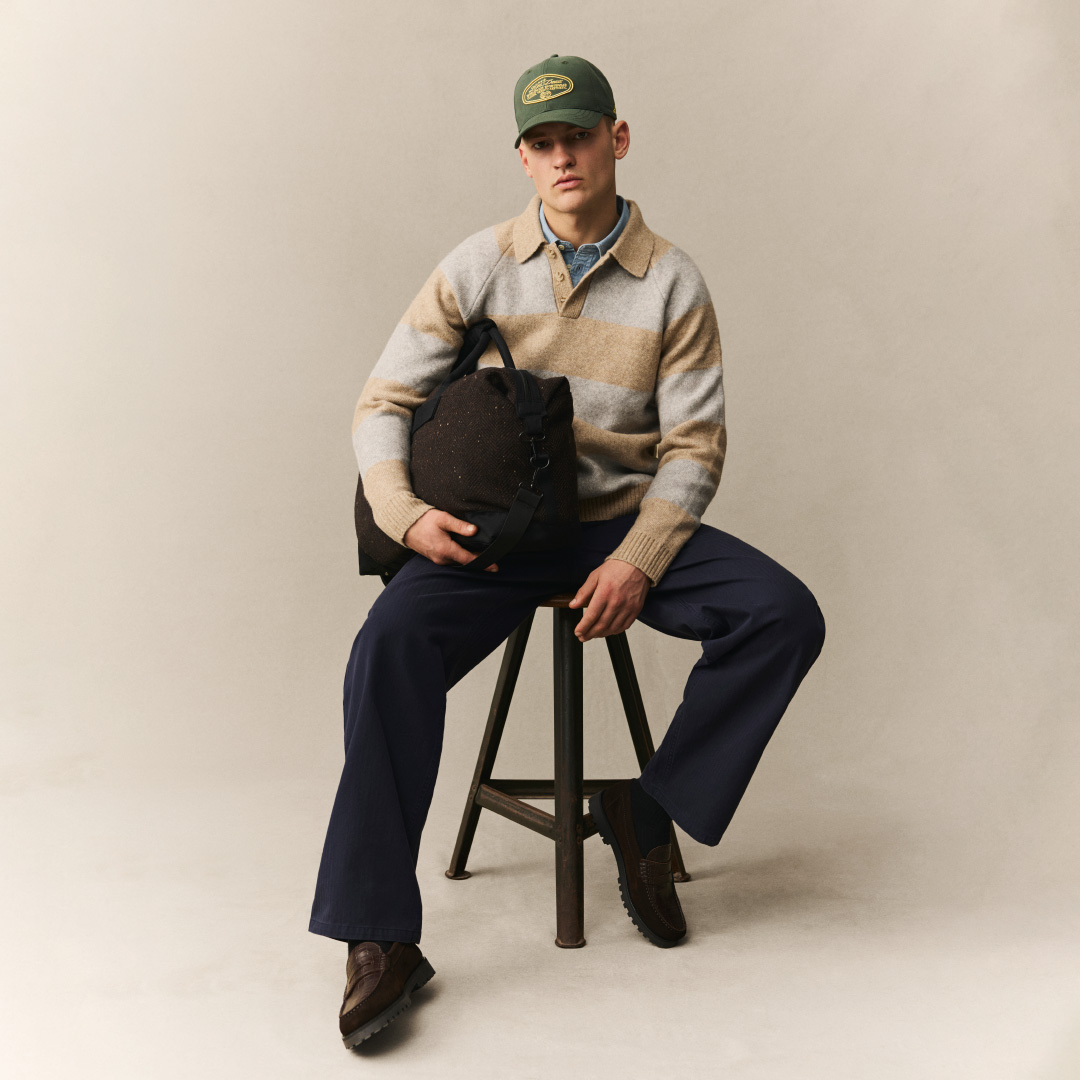 striped sweater, polo collar, cargo bag, baseball cap, dark pants