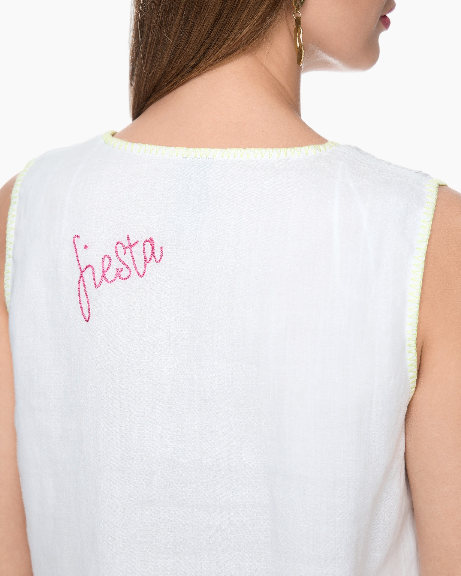 white sleeveless top, embroidery, pink text, neon stitching, back view