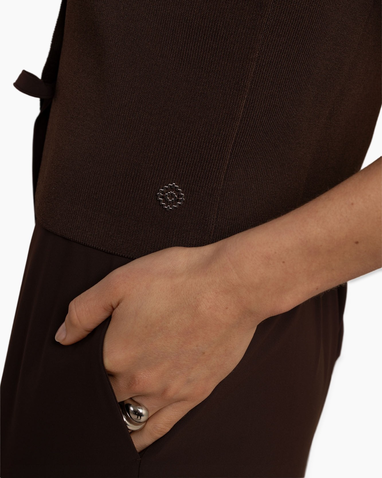 brown top, knit fabric, metallic emblem, short sleeve, pocket detail